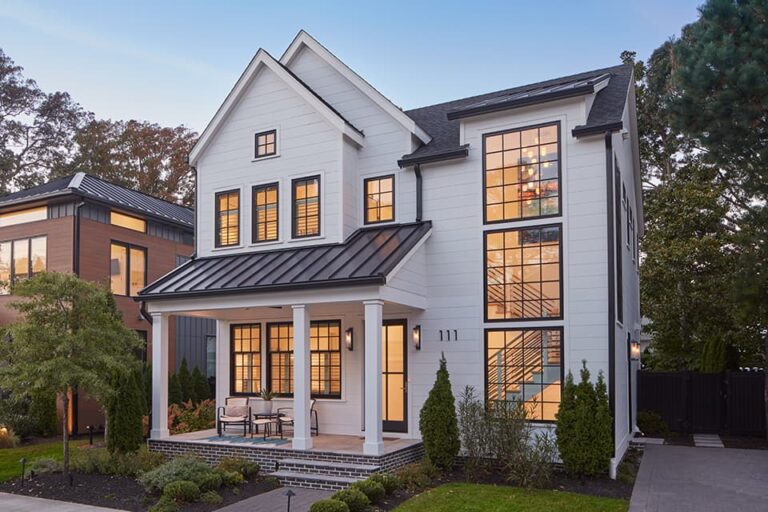 Modern coastal home with large windows and glowing evening light